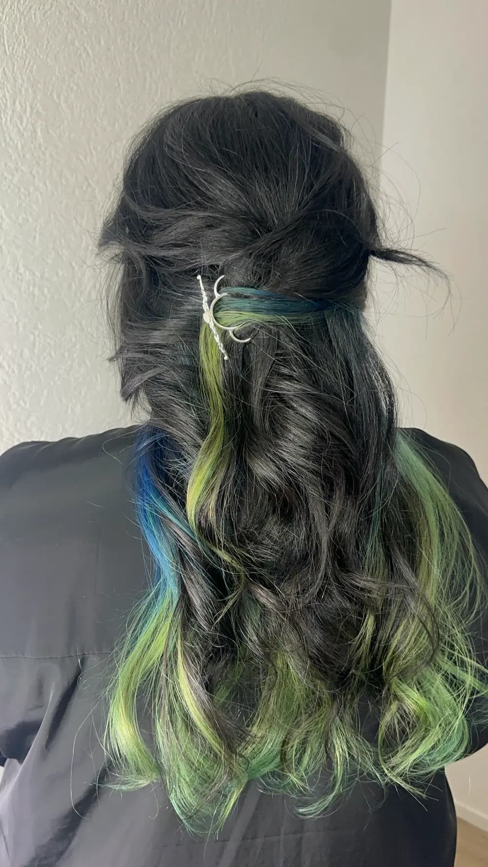 Coloration fantaisie bleue et verte sur cheveux foncés, coiffure ondulée avec barrette