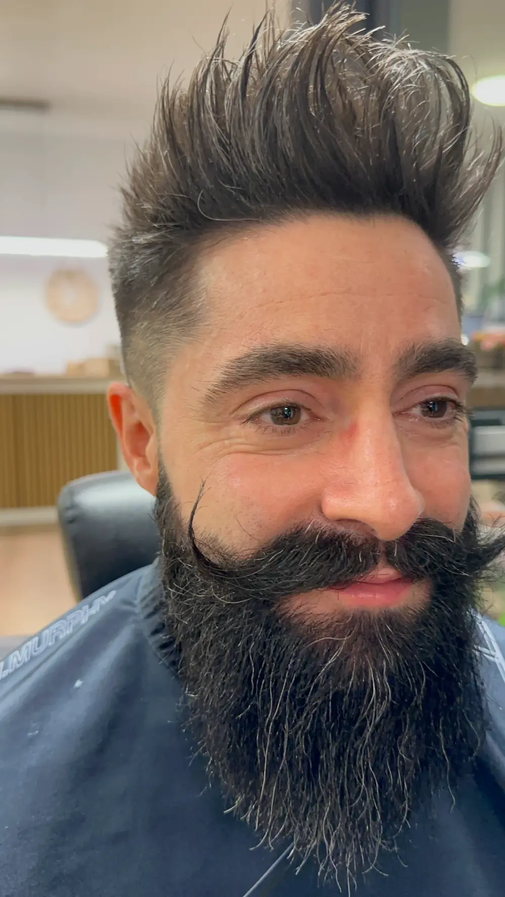 Coupe homme dégradée avec barbe et moustache sculptées au salon