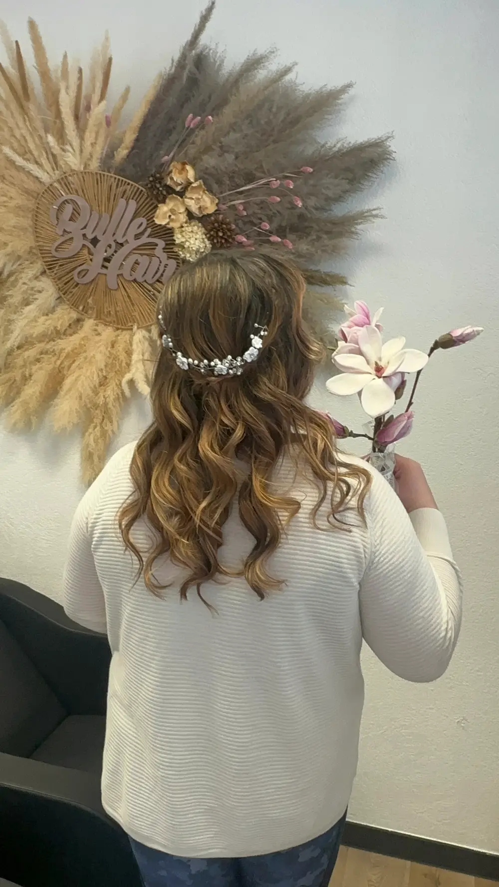 Coiffure événementielle bouclée avec accessoire perlé, devant le logo Bulle Hair