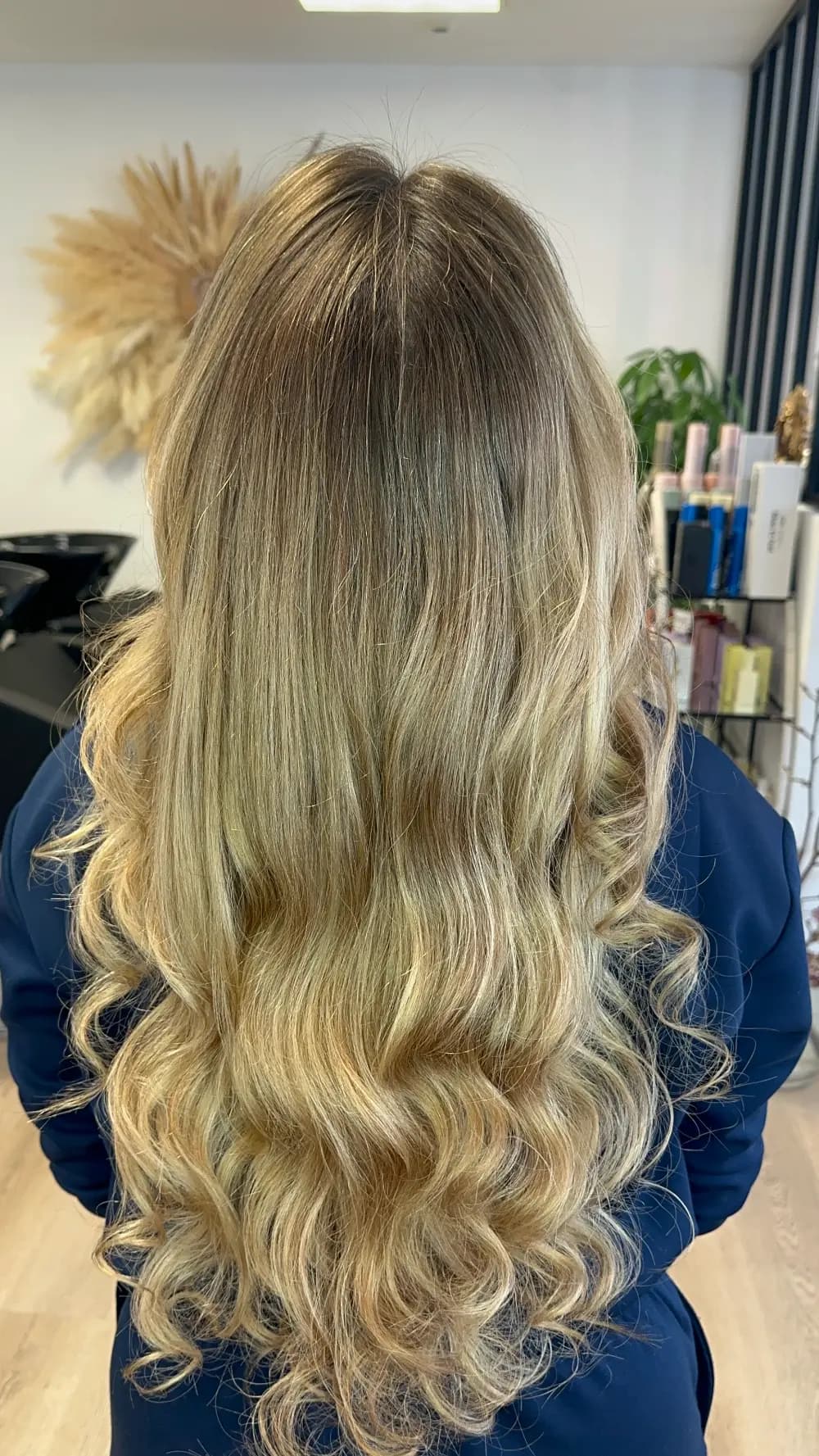 Balayage blond ombré naturel sur cheveux longs bouclés